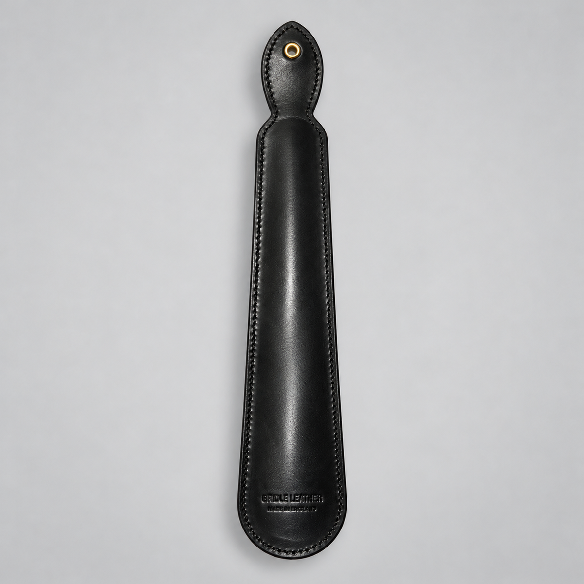 Reverse of black leather shoe horn showing hanging eyelet