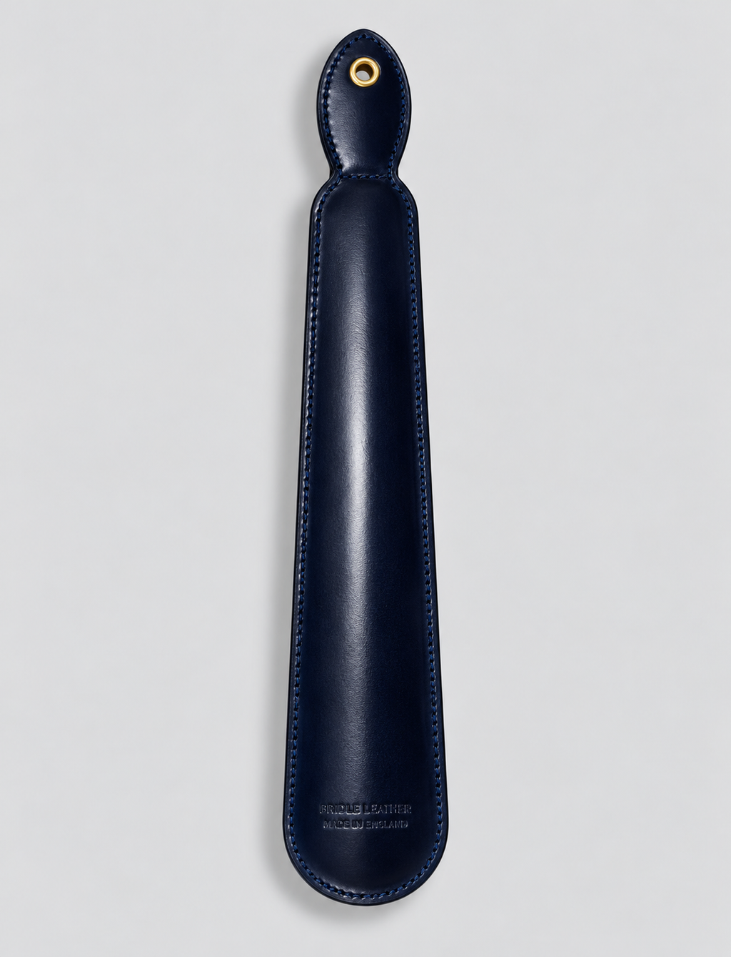 Reverse of navy leather shoe horn showing hanging eyelet