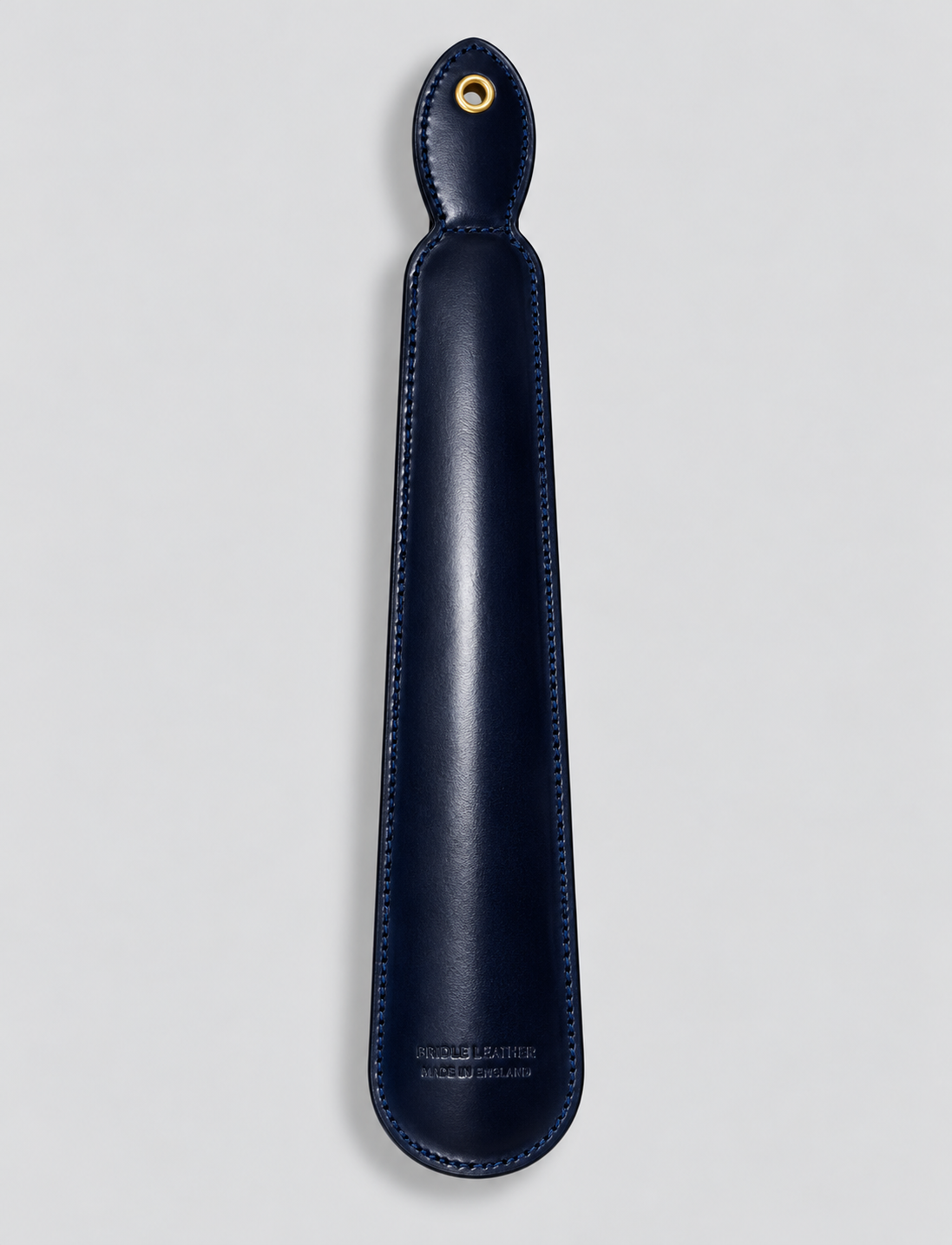 Reverse of navy leather shoe horn showing hanging eyelet