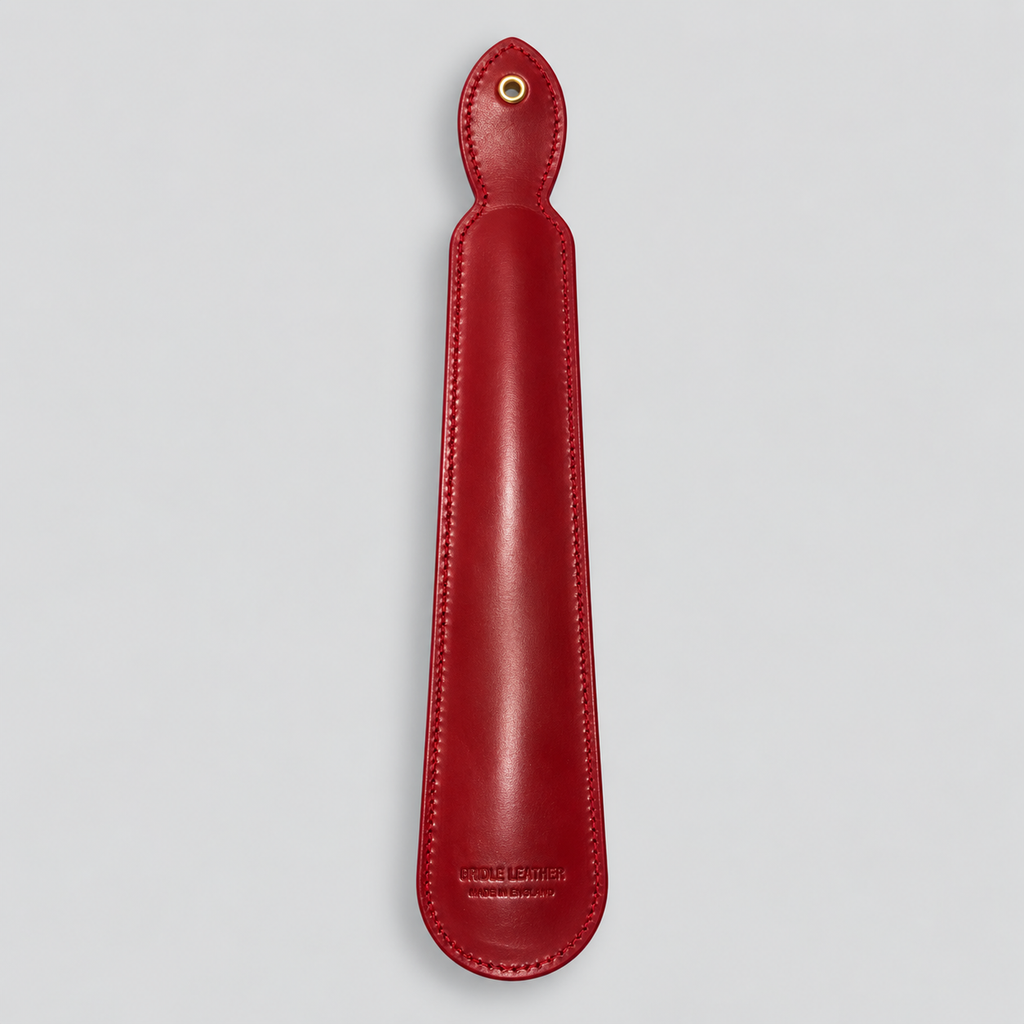 Reverse of red leather shoe horn with hanging eyelet